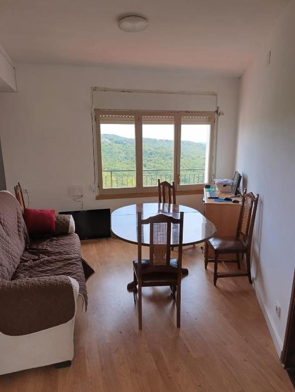 Salón comedor compartido con ventana a la montaña