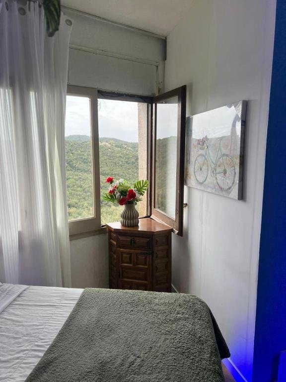 Dormitorio junto a una gran ventana